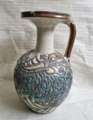 إبريق سيراميكي متعدد الألوان مثبت على المعدن